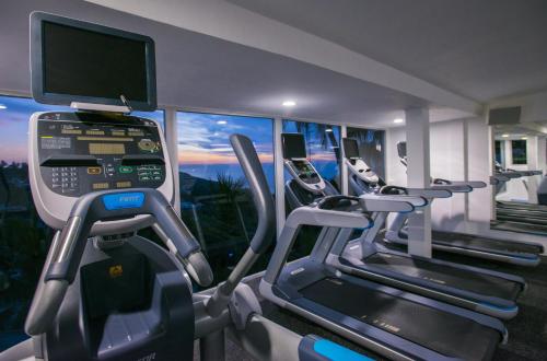 a gym with several treadmill machines and a television at Las Brisas Acapulco in Acapulco