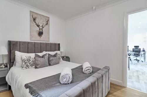 um quarto com uma cama grande e chinelos em Lavish Rayleigh Apartment - Small-Med dog OK em Rayleigh