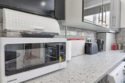 a kitchen with a microwave and a counter top at Lavish Rayleigh Apartment - LMV Property in Rayleigh