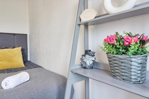 a vase of pink flowers sitting on a shelf at Lavish Rayleigh Apartment - Small-Med dog OK in Rayleigh