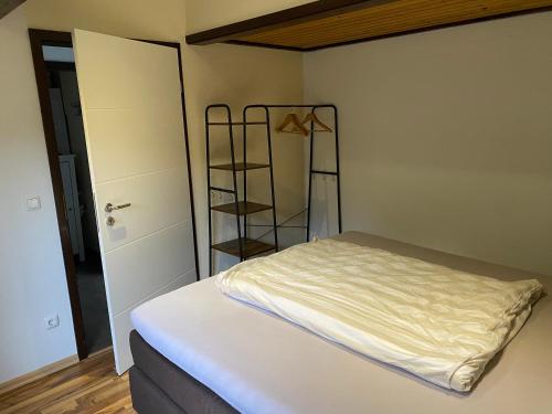 a small bedroom with a bed and a shelf at Henneliebe am Hennesee in Meschede