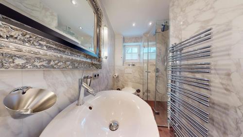 a bathroom with a white sink and a shower at Sylt pur in Munkmarsch