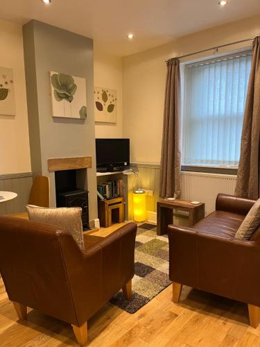 a living room with two couches and a television at Daffodil Cottage in Cockermouth