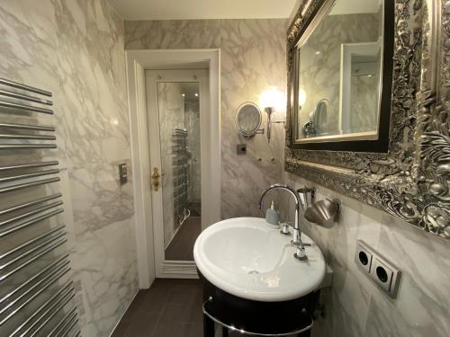 y baño con lavabo, espejo y ducha. en Inselliebe en Munkmarsch
