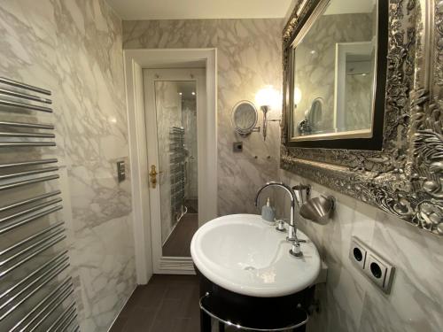 ein Badezimmer mit Waschbecken, Spiegel und Dusche in der Unterkunft Inselliebe in Munkmarsch