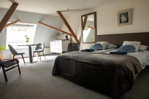 a bedroom with a bed and a table and chairs at Bed and Breakfast Lauwersstate in Paesens