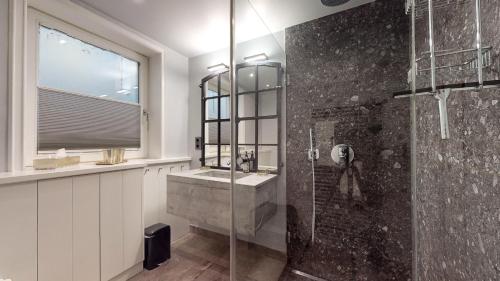 a bathroom with a glass shower and a sink at Hafenliebe in Munkmarsch