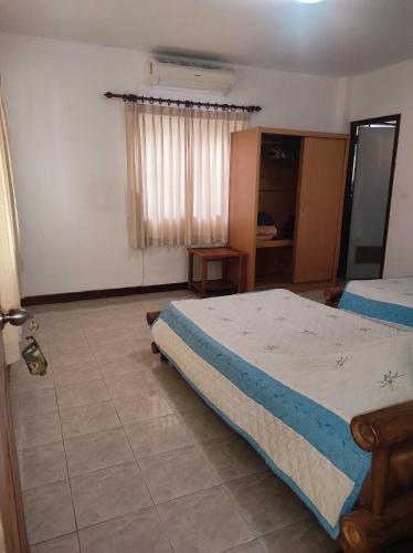 ein Schlafzimmer mit einem großen Bett und einem Fenster in der Unterkunft Chiang Mai Homey in Chiang Mai