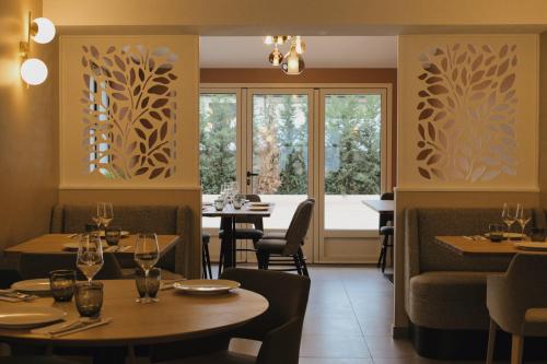 a restaurant with tables and chairs and windows at C La Suite in Pomponne
