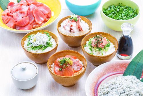 una mesa con tazones de comida y platos de comida en Vessel Inn Chiba Ekimae, en Chiba