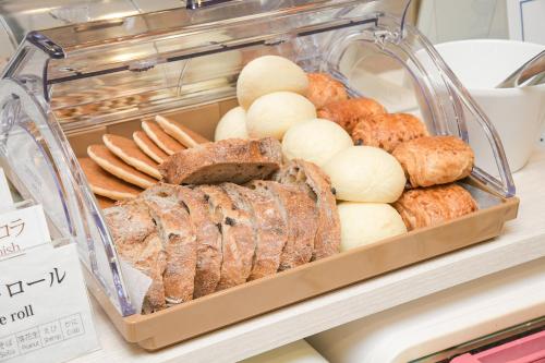 a display case with various types of bread and pastries at Vessel Inn Chiba Ekimae in Chiba