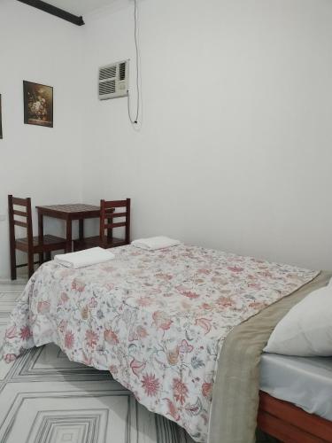 a bedroom with a bed with a floral bedspread at GmL Lodge House in Daanbantayan