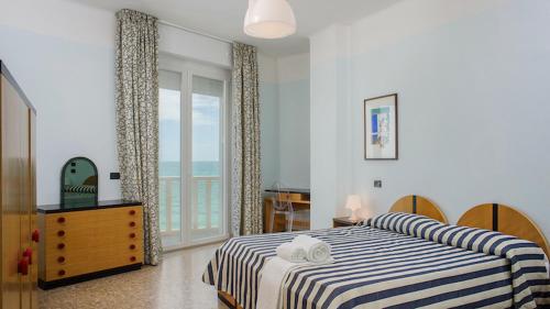 a bedroom with a bed and a window with the ocean at Hotel Marcelli in Numana