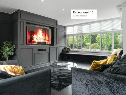 a living room with a fireplace and a tv at Gorgeous 6 Bed House - Hot Tub - Wifi & Large Garden - Lichfield 40ST in Shenstone