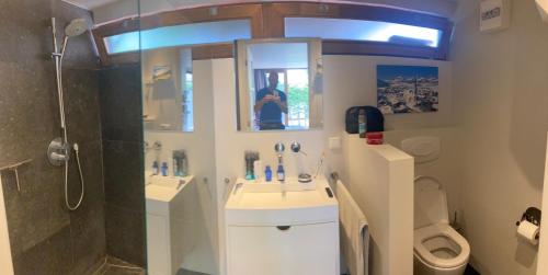 a bathroom with two sinks and a shower and a toilet at Koetshuis aan het water 3 bedroom villa in Voorburg