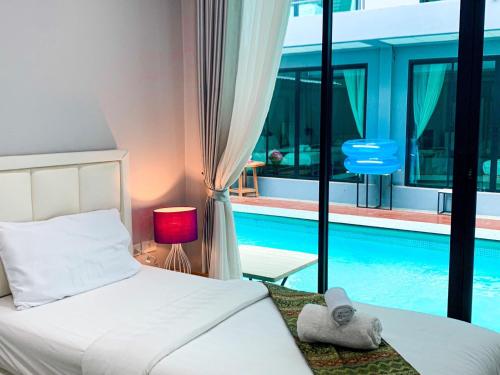 1 dormitorio con cama y piscina en โรงแรม ทรี บริดจ์ โฮเทล, en Nan