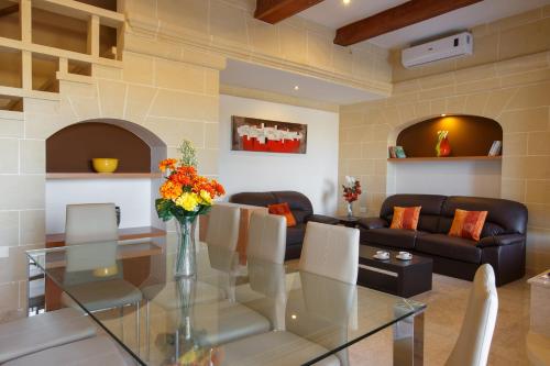 a living room with a glass table and a couch at Carini Farmhouses in Għarb