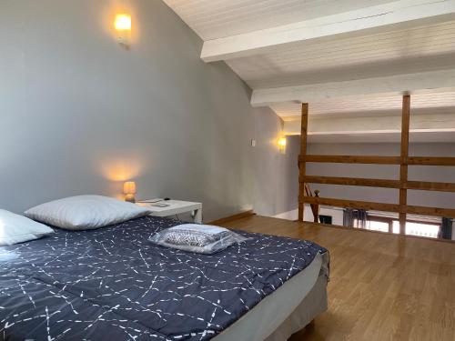 a bedroom with a bed with a blue comforter at La Casa de Bianca in Teyran