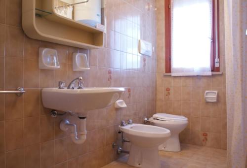 ein Bad mit einem Waschbecken und einem WC in der Unterkunft Bibione getaway - comfy flat in residence in Bibione