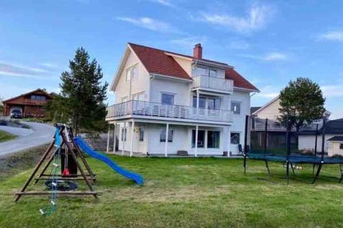 a house with a playground in front of a house at Leilighet sentralt på Senja in Silsand