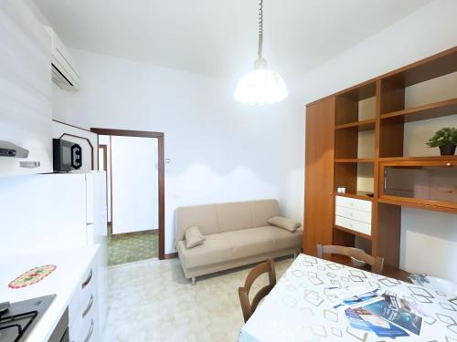 cocina y sala de estar con sofá y mesa en Casa Diana - ArgonautiVacanze, en Porto Azzurro