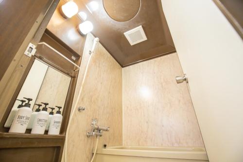 La salle de bains est pourvue d'une douche et d'un miroir. dans l'établissement Walk to Higashi-Nakano sta. COB3, à Tokyo