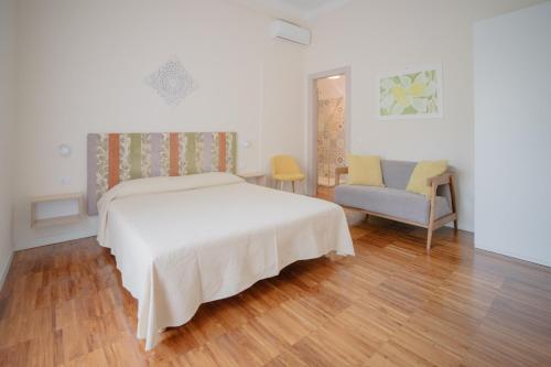 a bedroom with a white bed and a chair at Fiordarancio Room Rental in Monterosso al Mare