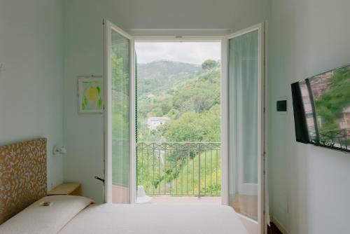 a bedroom with a bed and a window with a view at Fiordarancio Room Rental in Monterosso al Mare