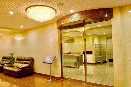 a lobby with a leather chair and a desk at Kyoto Universal Hotel Karasuma in Kyoto