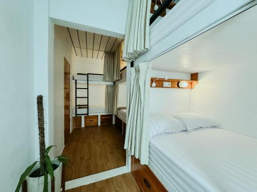 a small bedroom with a bed and a staircase at De Nata in Labuan Bajo