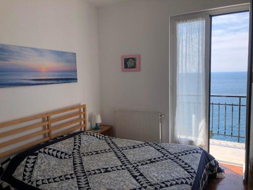 een slaapkamer met een bed en uitzicht op de oceaan bij DAVANTI AL MARE E A PORTOFINO - IN FRONT OF THE SEA AND PORTOFINO in Zoagli