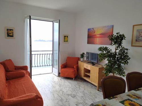 een woonkamer met een tv en een bank en stoelen bij DAVANTI AL MARE E A PORTOFINO - IN FRONT OF THE SEA AND PORTOFINO in Zoagli