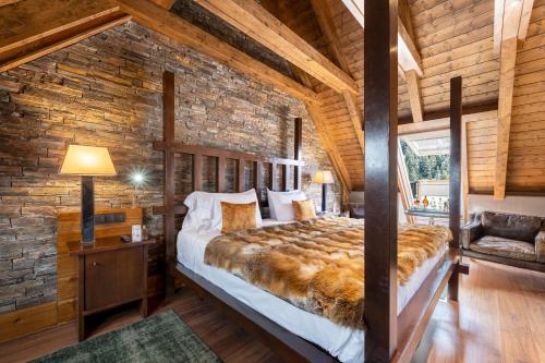 een slaapkamer met een groot bed in een bakstenen muur bij Hotel Val de Neu G.L. in Baqueira-Beret