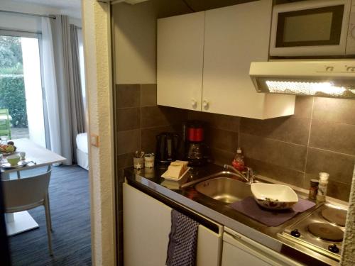 a kitchen with a sink and a counter top at Logis Hôtel de la Plage in La Cotinière