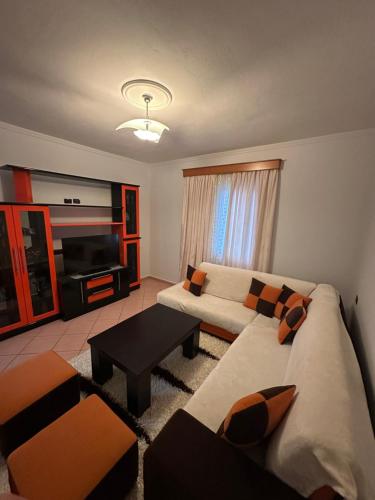 een woonkamer met een bank en een tv bij Villa Kevin's in Sarandë