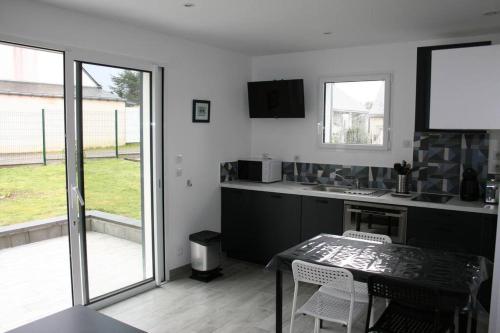 une cuisine avec une table et des chaises et une fenêtre dans l'établissement maison sud Morbihan proche mer très calme, à Camoël