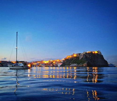 a sailboat in the water with a city in the background at Palazzo Palumbo in Procida