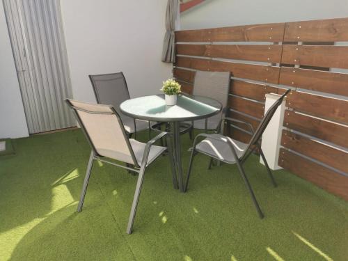 einen Tisch und Stühle in einem Zimmer mit grünem Teppich in der Unterkunft La casita de Meiro in Bueu