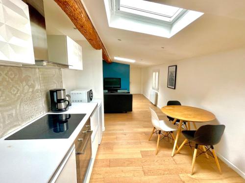 une cuisine avec une table et des chaises ainsi qu'une chambre dans l'établissement Place de la Comédie - Magnifique T2 au calme, à Montpellier
