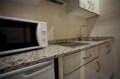 une cuisine avec évier et four micro-ondes sur un comptoir dans l'établissement Oliver's Hostel, à Dublin