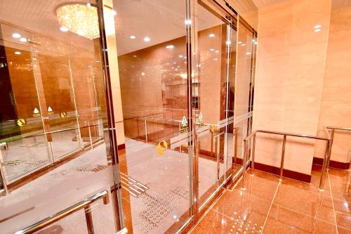 a bathroom with a shower and a glass door at Himeji Ekimae Universal Hotel Minamiguchi in Himeji