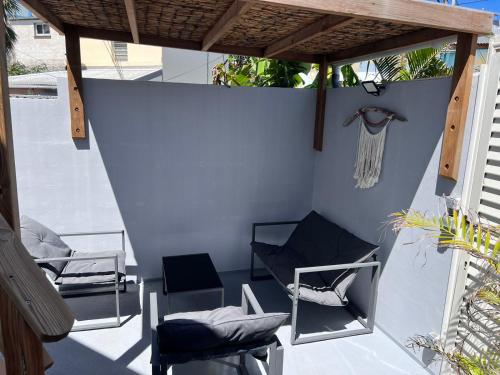 a patio with two chairs and awning at Le Liyann in Saint-Pierre