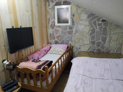 Habitación pequeña con 2 camas y TV. en Villa Rashkov, en Kočani