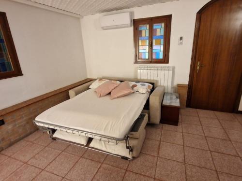 uma cama com almofadas cor-de-rosa num quarto em Venezia Travel em Chioggia