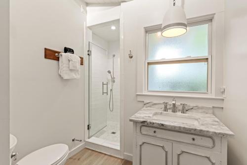 ein weißes Badezimmer mit Waschbecken und Dusche in der Unterkunft Perfect Symmetry - 520 Beach - 4 Bedrooms in Demere Park