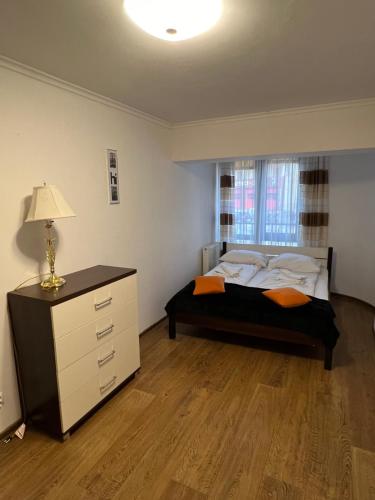 a bedroom with a bed and a dresser and a window at Holiday Apartments in Krynica Zdrój