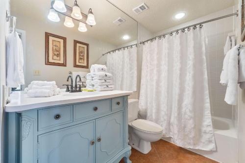 a bathroom with a blue cabinet and a toilet at Seachase 1503W in Orange Beach