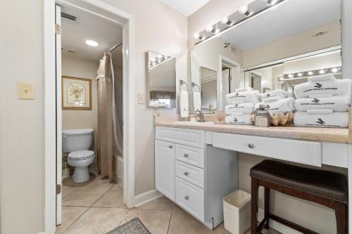 a bathroom with a sink and a toilet and mirrors at Perdido Sun 512 in Perdido Key