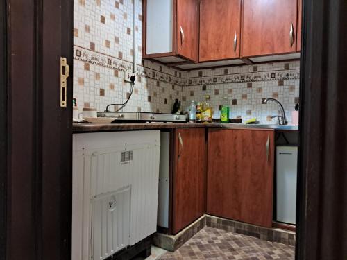 a kitchen with wooden cabinets and a sink at Top House Zayed Airport in Abu Dhabi