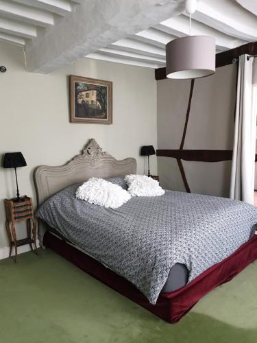 a bedroom with a bed with two pillows on it at LA GAUDINIERE in Lyons-la-Forêt